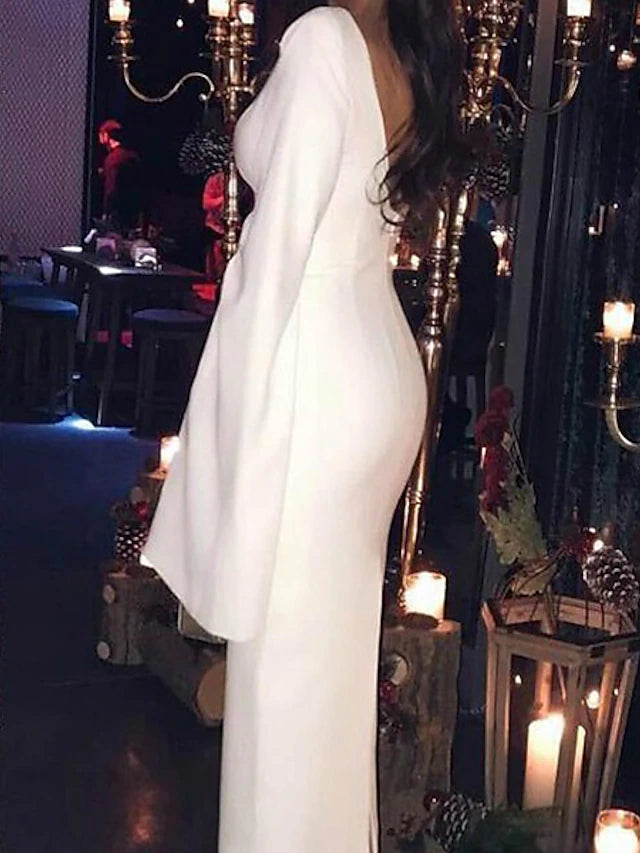 Side profile of a woman in the dark long-sleeve tea-length cocktail dress.