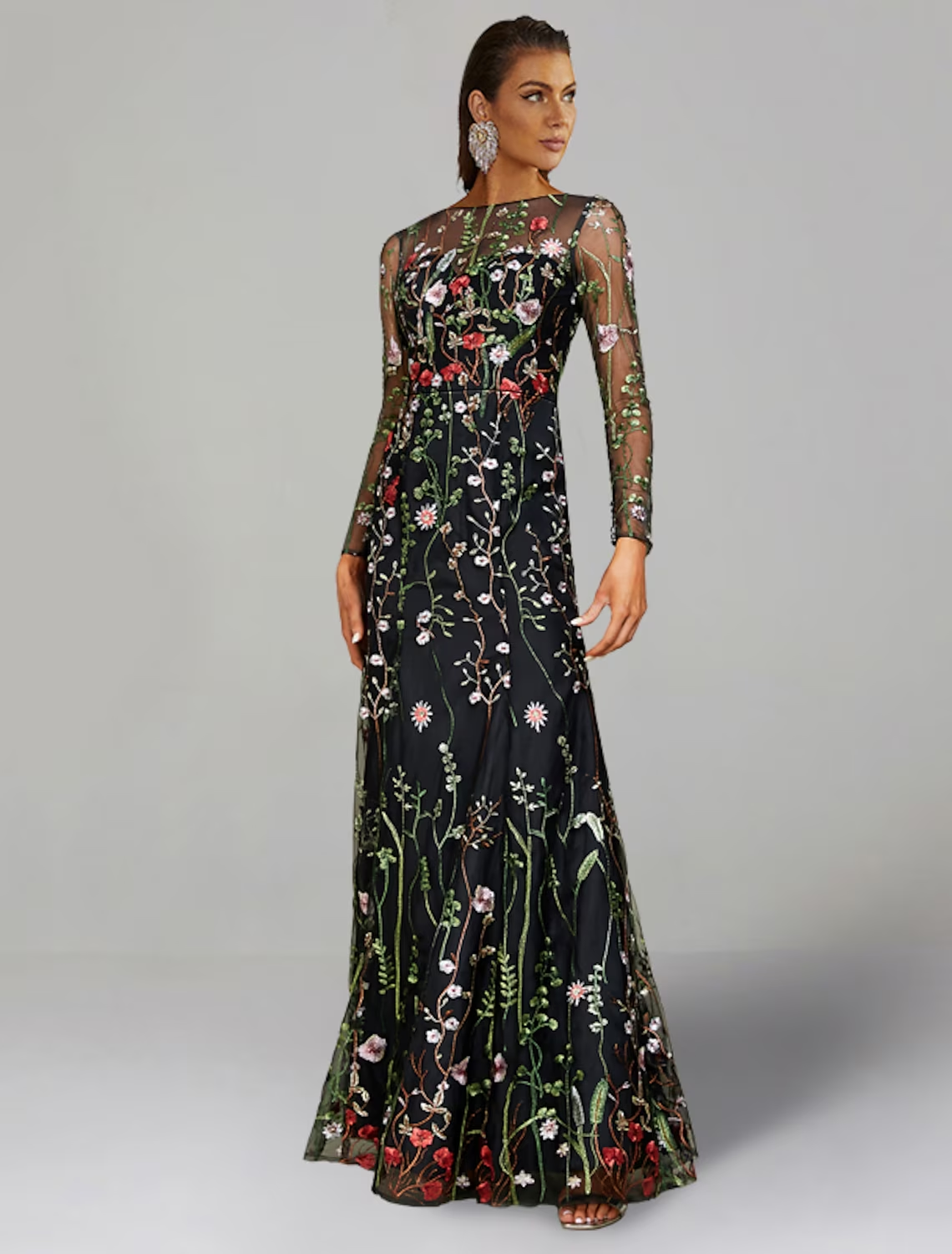 Model wearing an elegant long sleeve jewel neck sheath floral embroidered tulle floor length wedding guest dress.