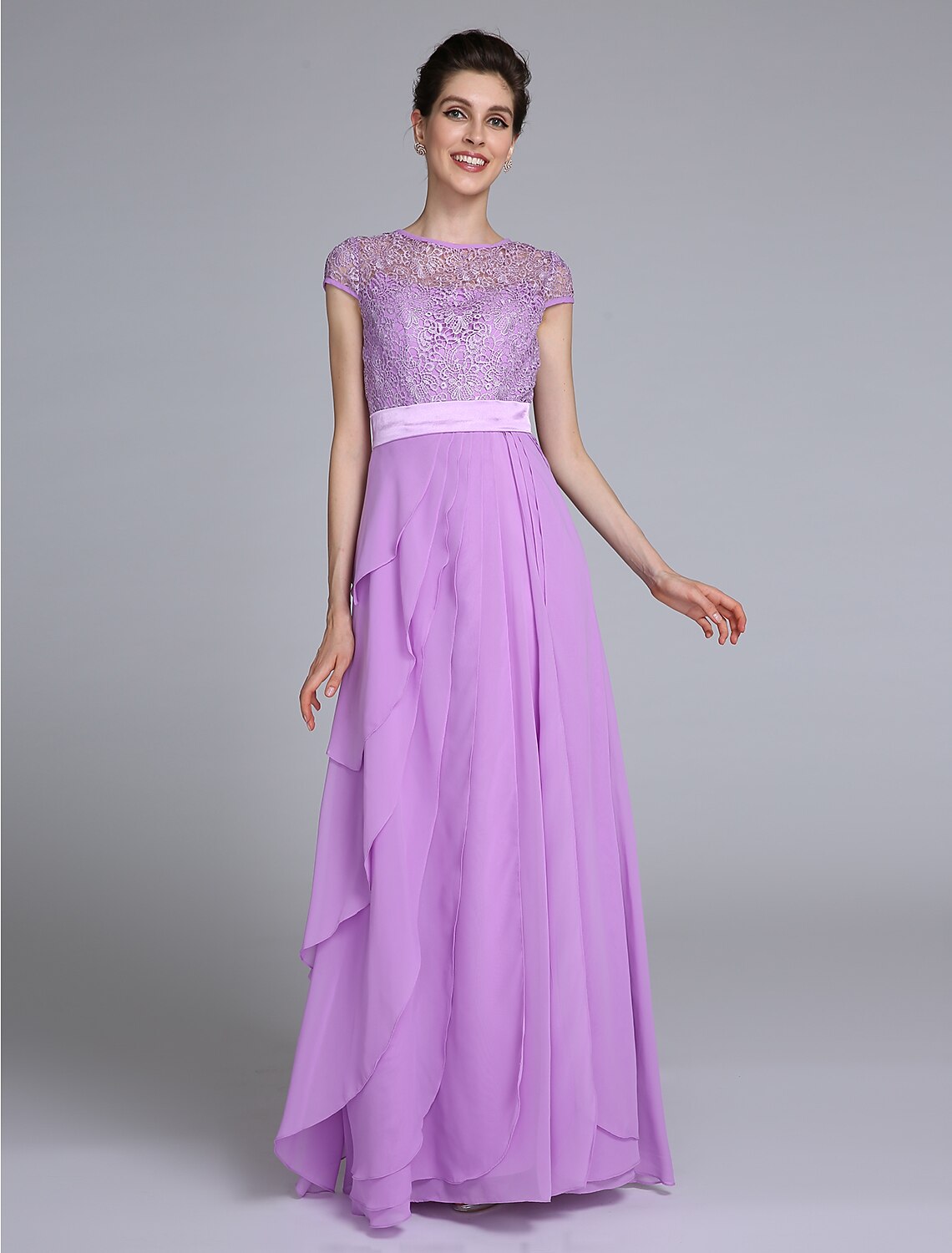Woman wearing an elegant navy blue sheath Mother of the Bride dress with jewel neck and short lace sleeves.