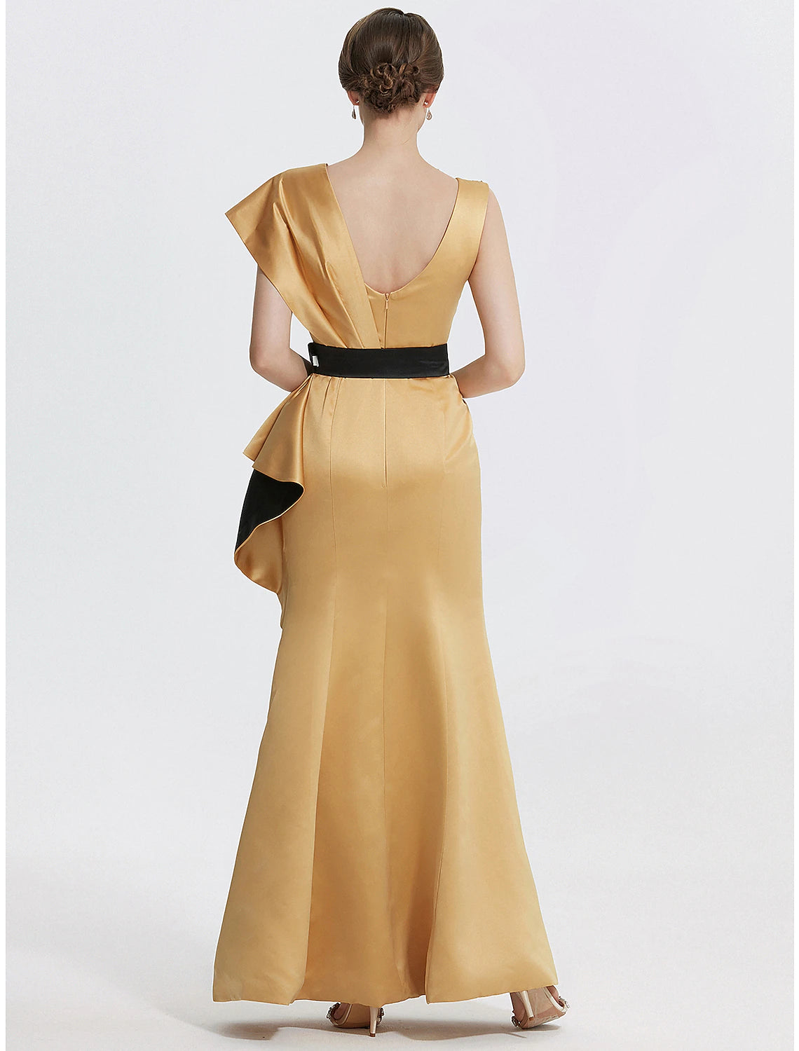 Back view of a woman wearing a floor-length sheath evening gown.