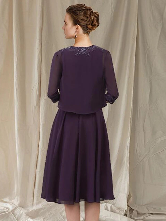 Detailed view of the knee-length hem and chiffon skirt of the dress.