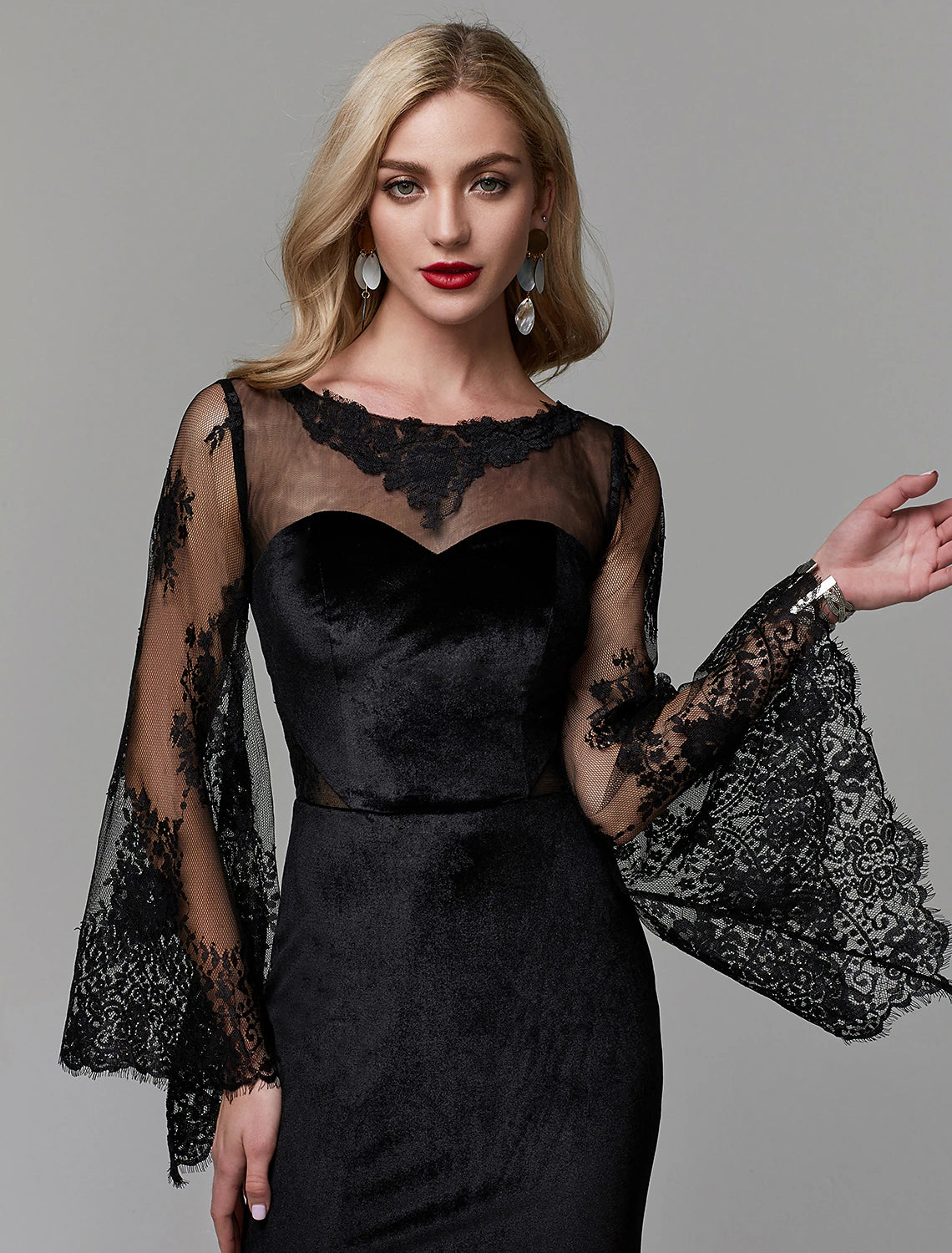 Model posing in a long sleeve wedding guest dress with a sheath silhouette.