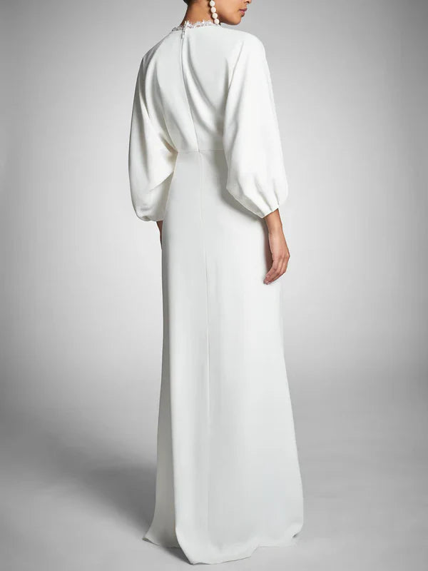 Floor-length bridal gown with long sleeves.