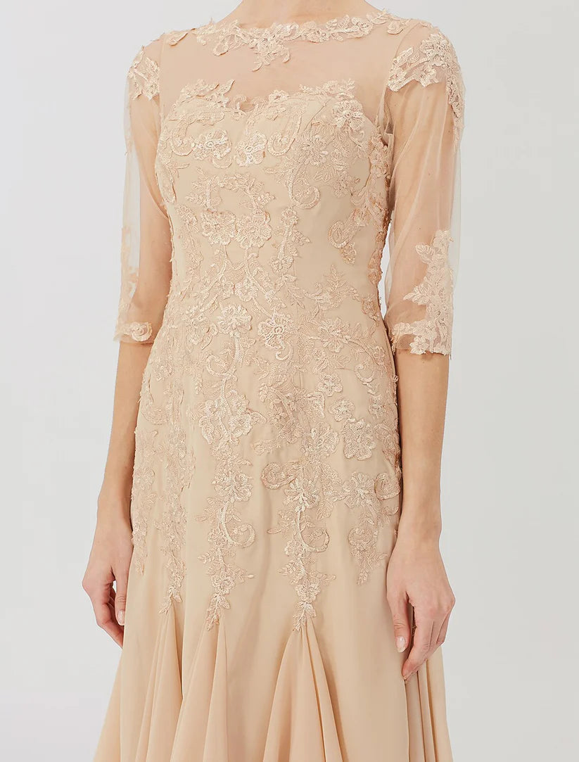 Woman posing in a classic knee-length Mother of the Bride dress with an illusion neck.