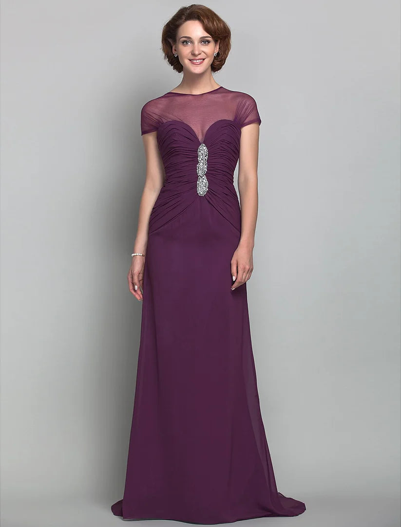 Elegant woman in a light blue sheath Mother of the Bride dress with jewel neck and beading.