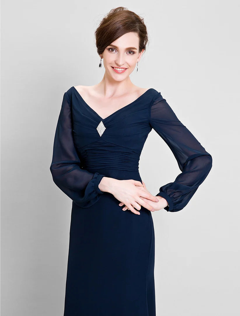 Close-up of the V-neckline and crystal brooch detail on the long-sleeve chiffon Mother of the Bride dress.