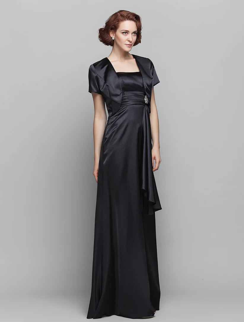 Close-up of the stretch satin fabric, ruched detail, tassel, and crystal brooch on the dress.