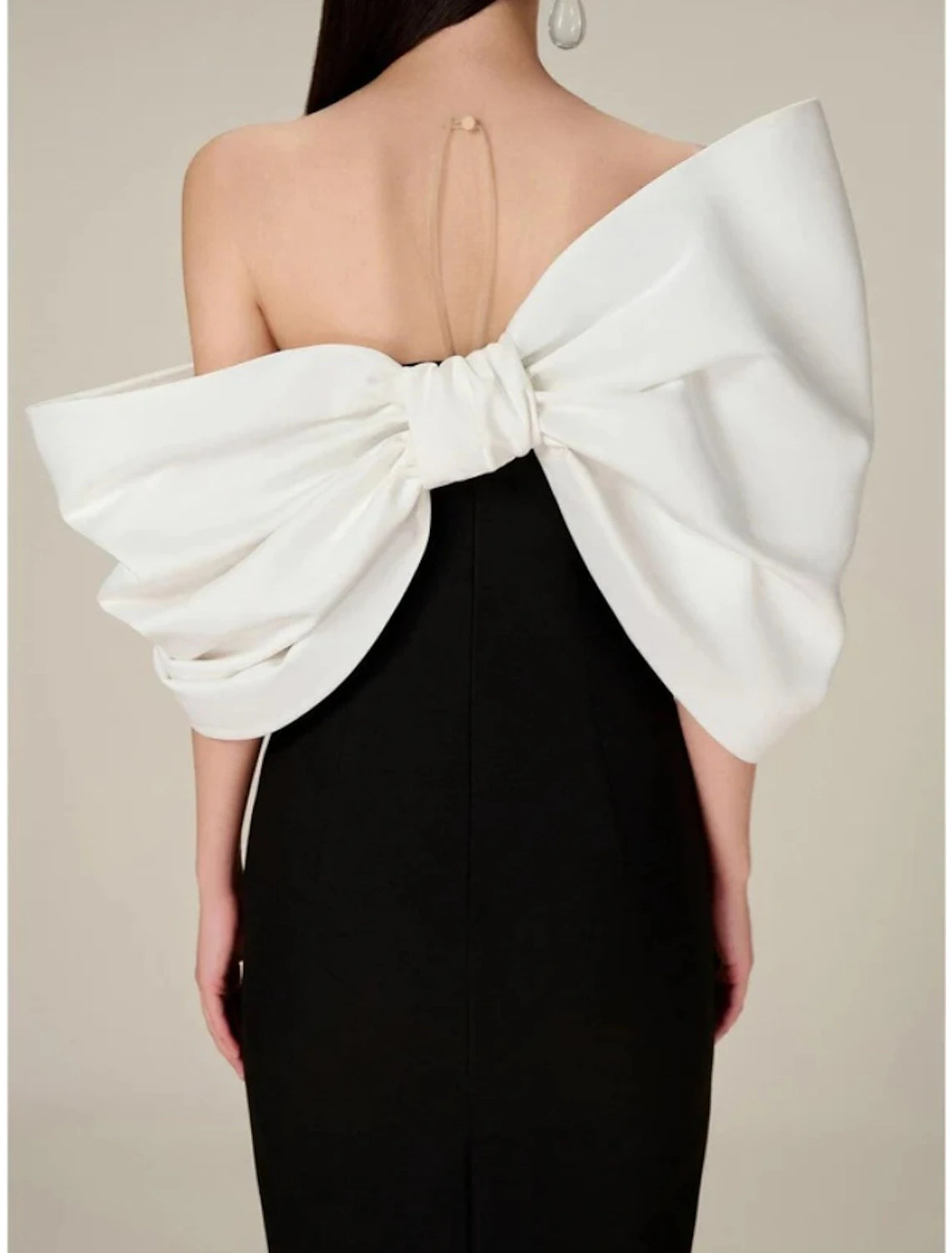 Back view of the sheath evening gown, highlighting the tea length and satin fabric.