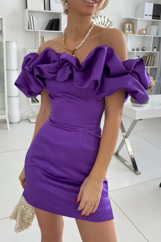 Woman wearing a short off-the-shoulder ruffled satin sheath dress.
