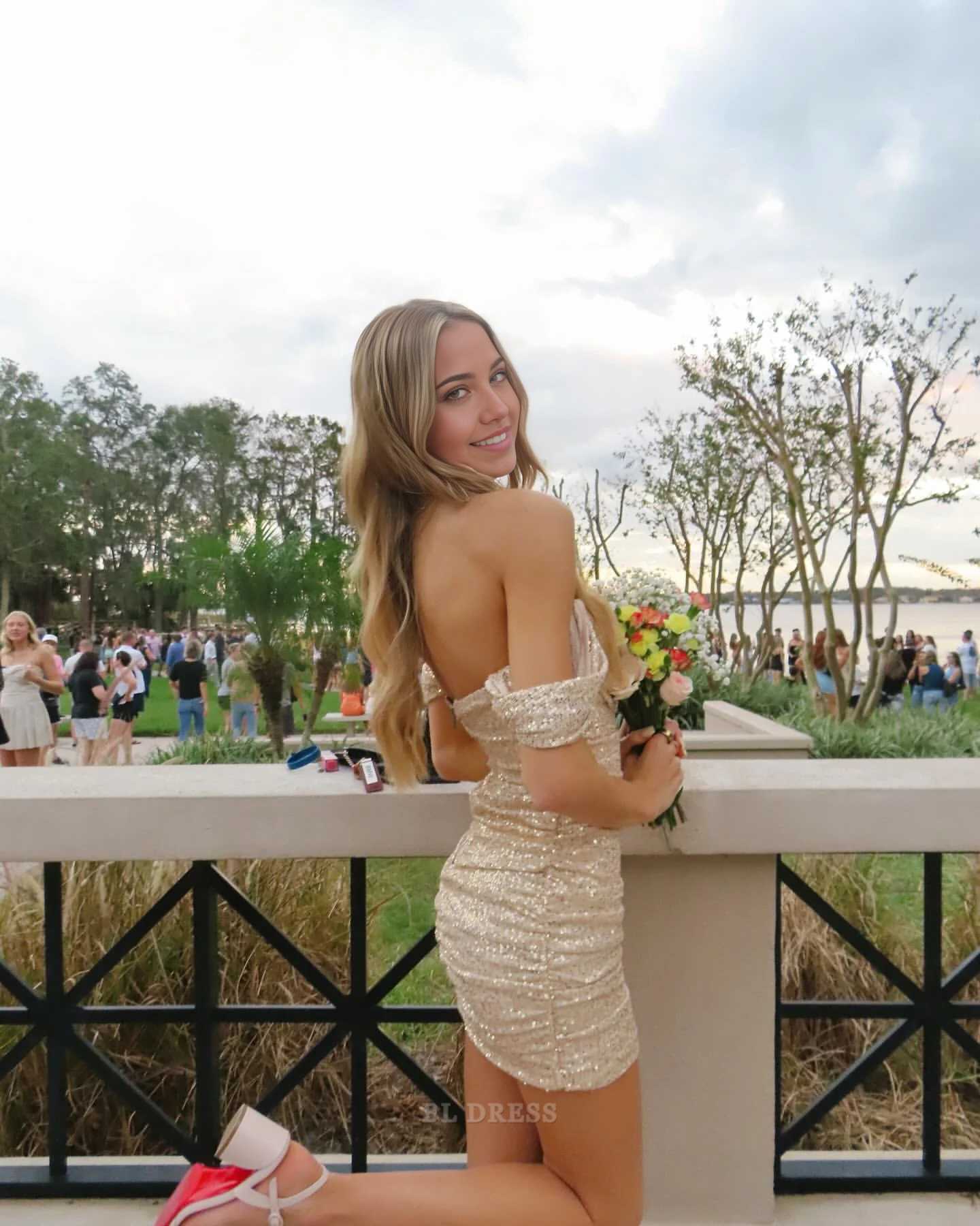 Back view of model in a stylish off-shoulder short sheath dress.