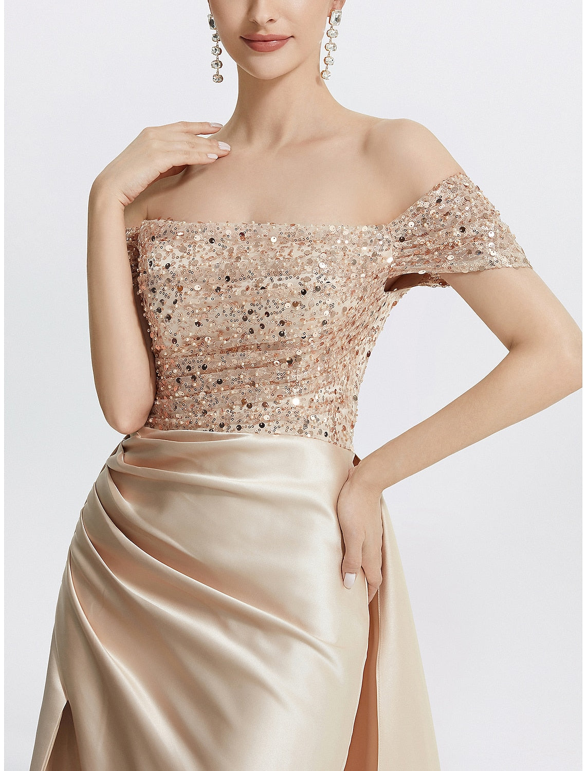 Full length view of a woman wearing the navy blue sequined off-shoulder formal dress.