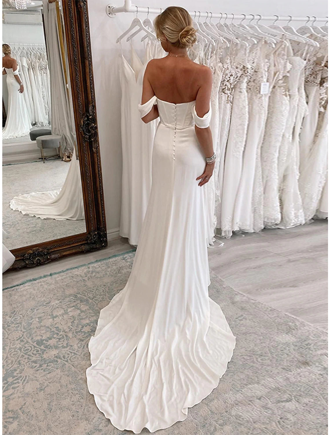 Close-up of the ruched stretch fabric and off-shoulder neckline on a formal bridal gown.