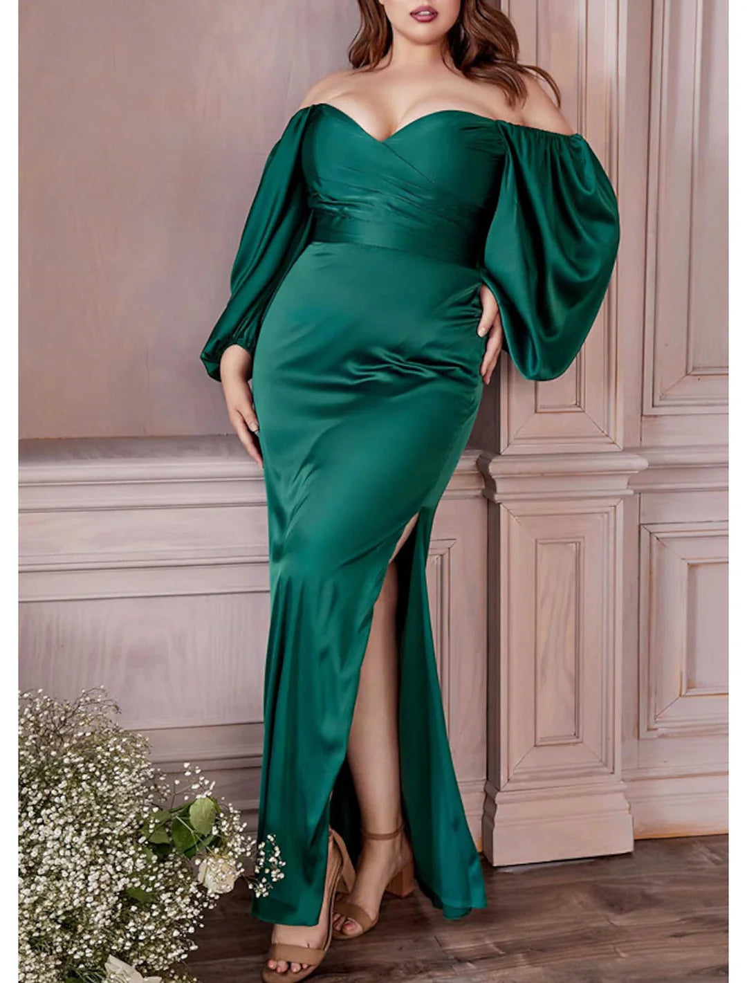 Back view of a model wearing a black sheath off-the-shoulder floor-length dress, highlighting the silhouette.