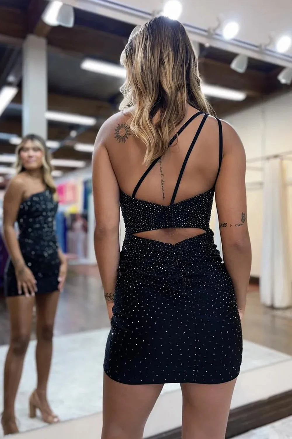 Close-up of the delicate beading detail on the one-shoulder sheath dress.