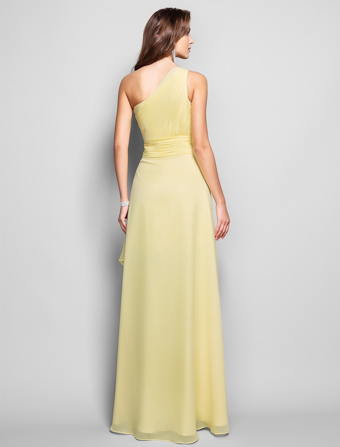 Back view of a woman wearing an elegant one-shoulder chiffon dress.