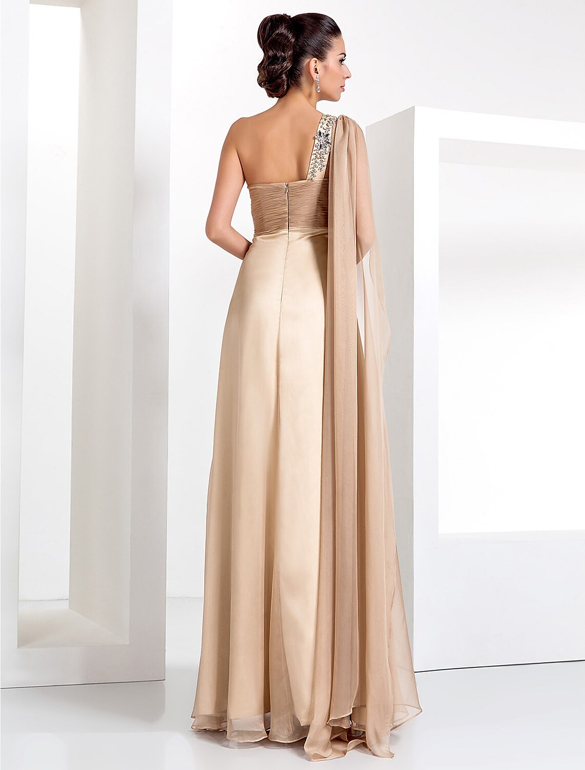Back view of a black one-shoulder formal dress with flowing chiffon skirt.