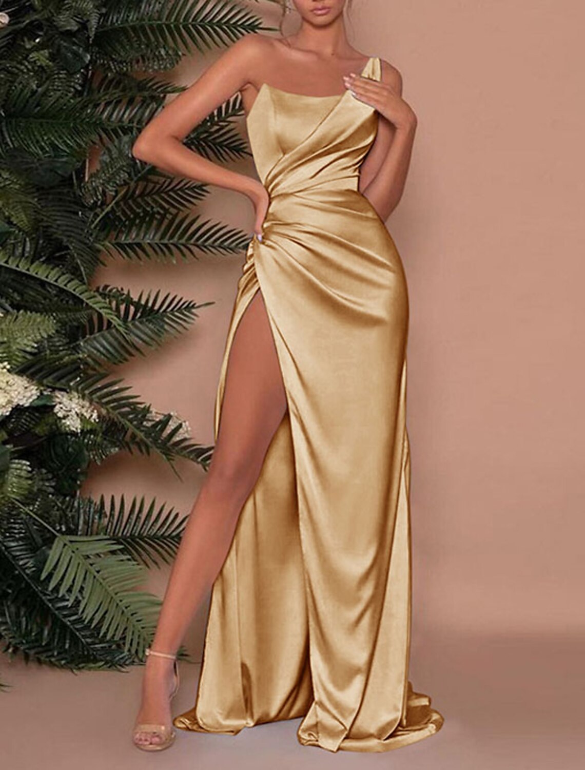 Side view of the dark blue one-shoulder dress, highlighting the ruched slit detail.