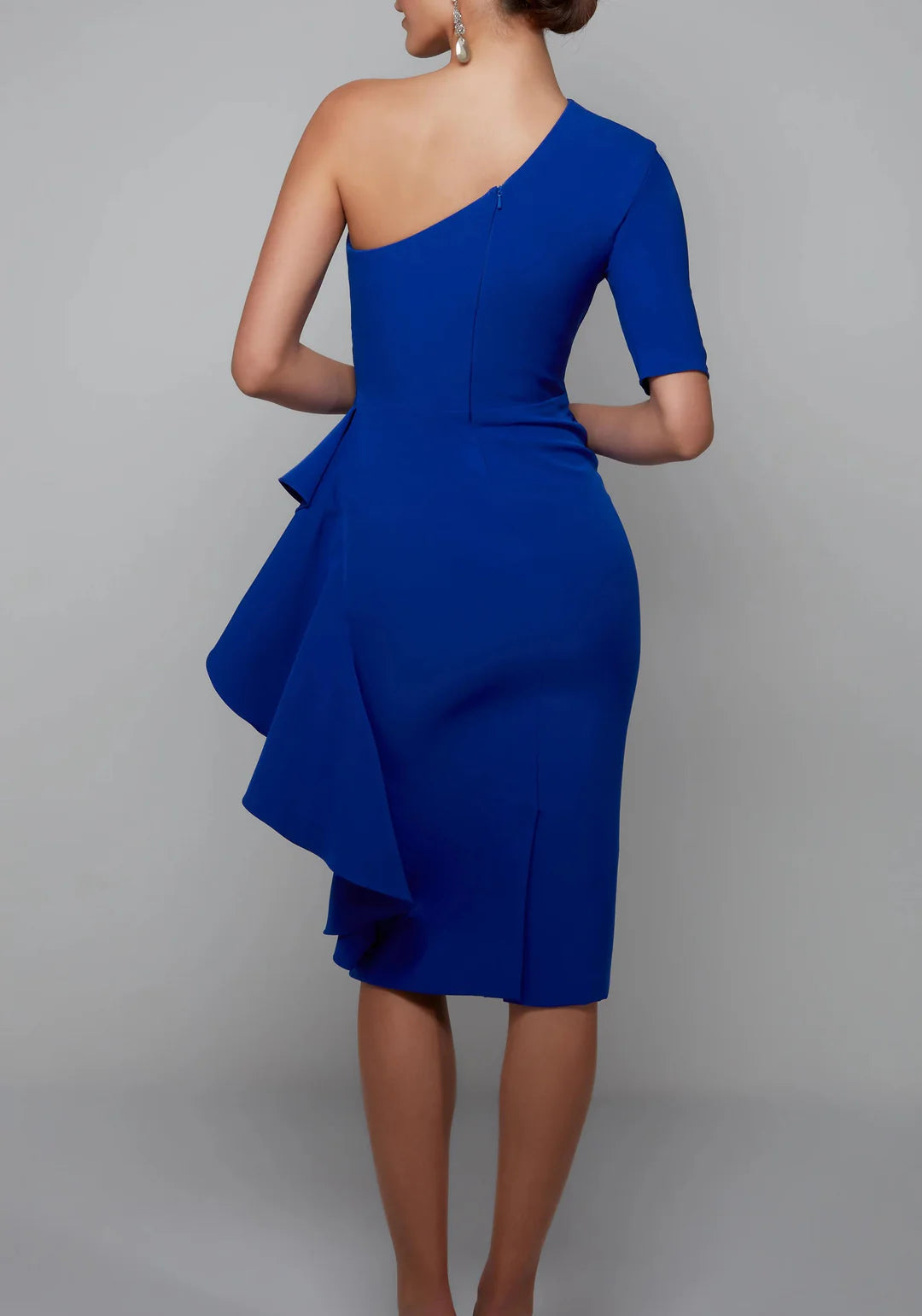Back view of a woman in a dark one-shoulder sheath dress.