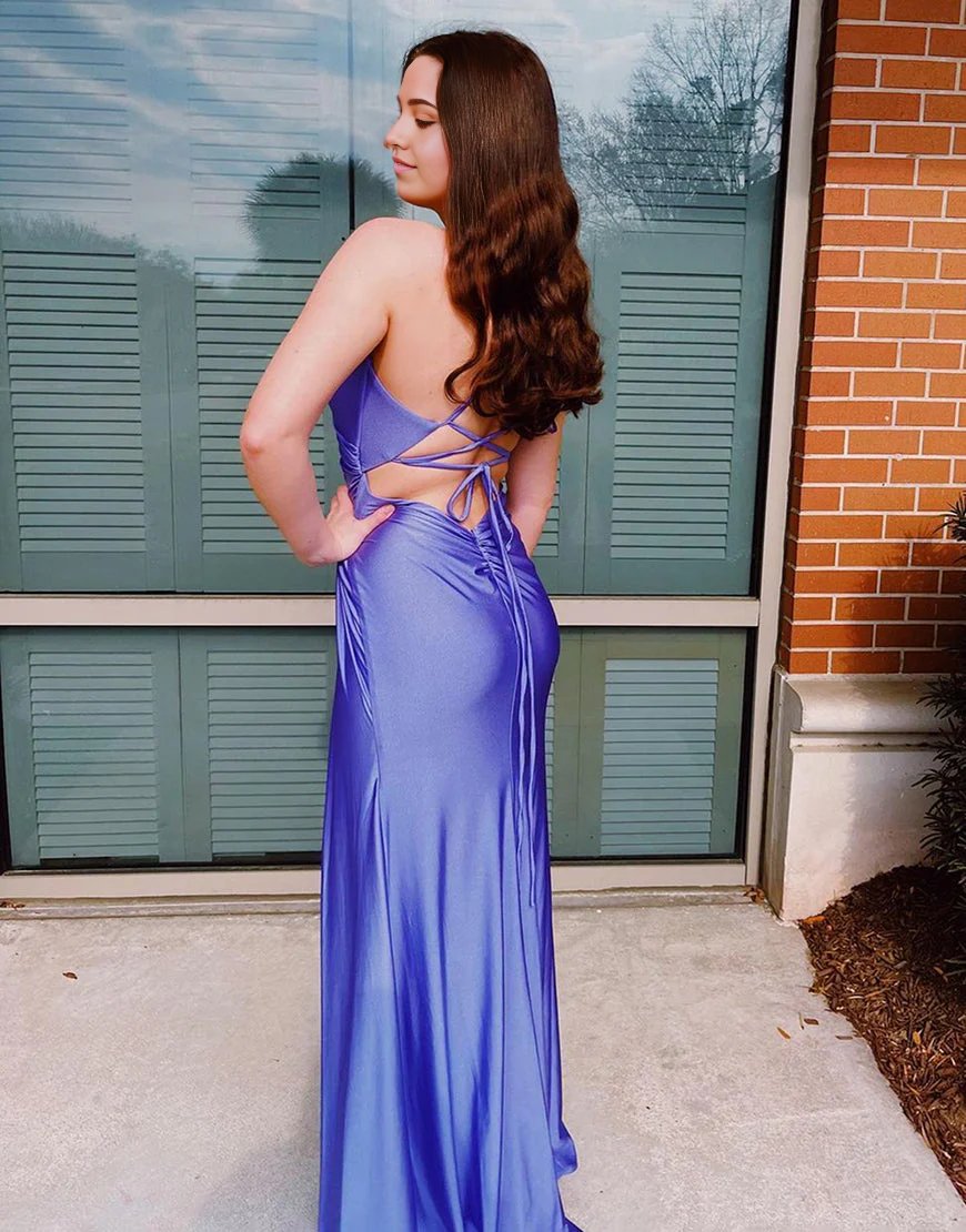 Back view of a woman in a long purple evening gown with spaghetti straps.