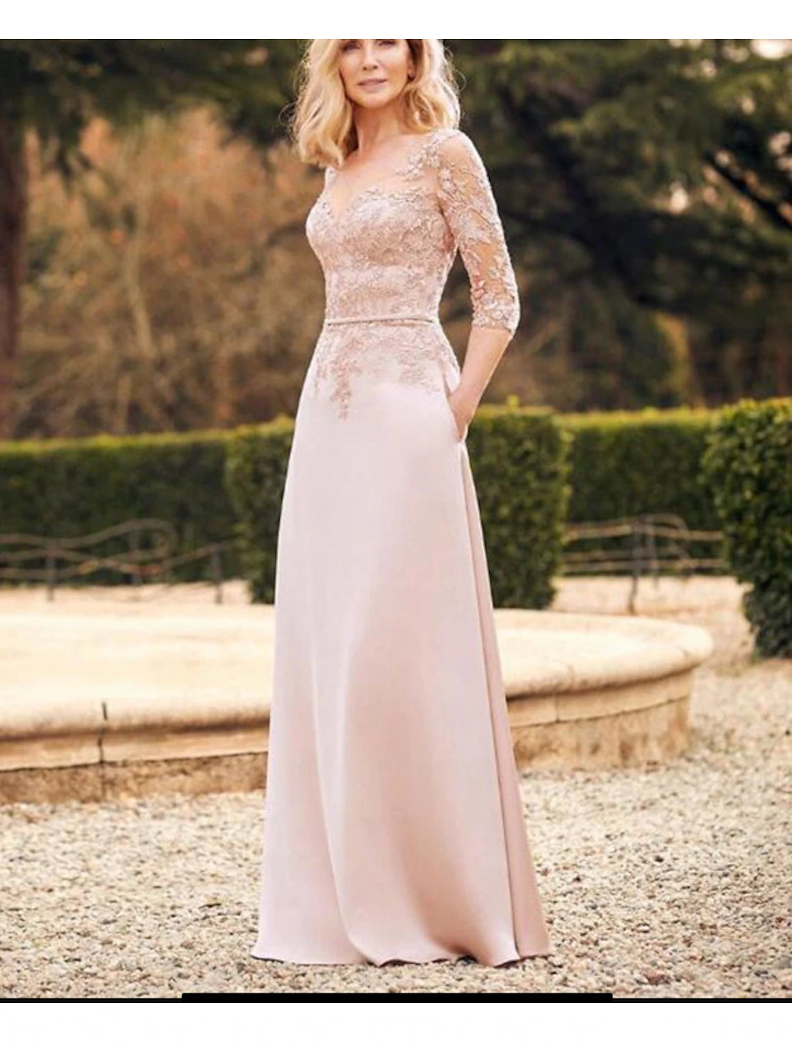 Elegant woman in a floor-length sheath satin mother of the bride dress with long sleeves and a jewel neck.