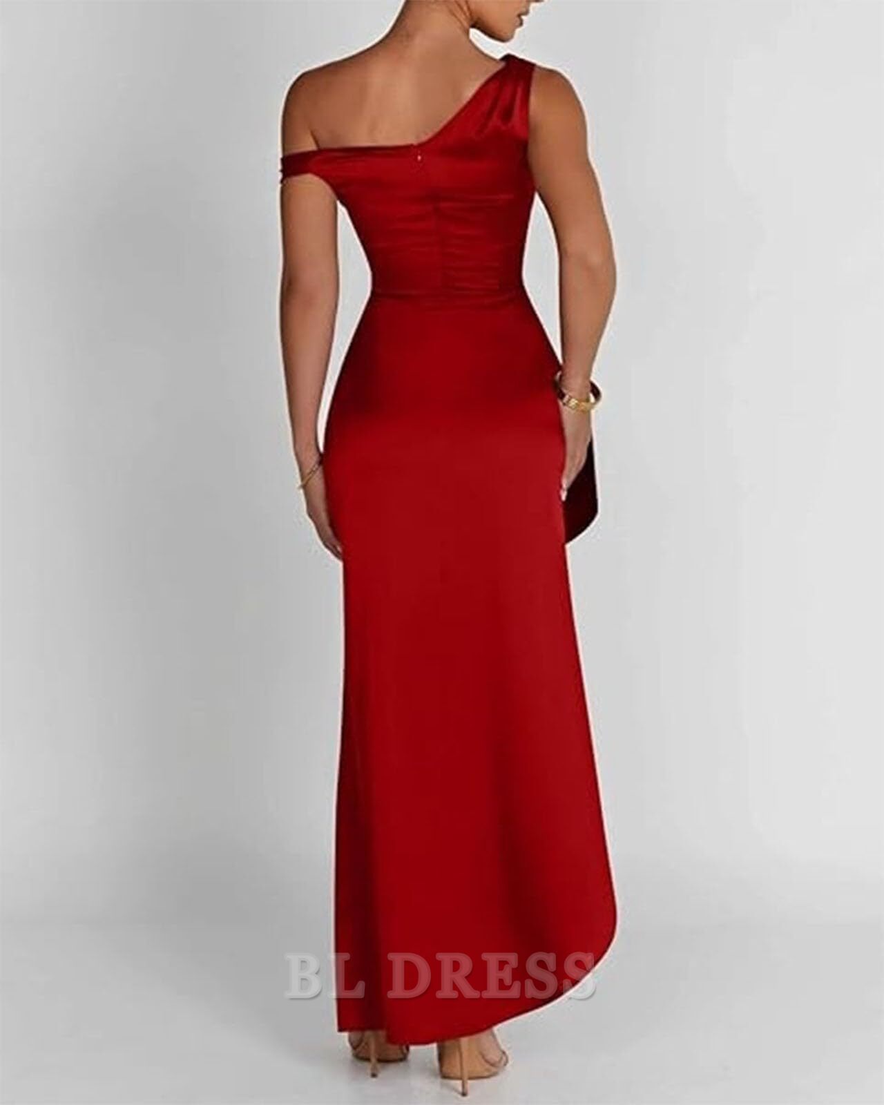 Side view of a woman posing in a long V-neck satin gown.