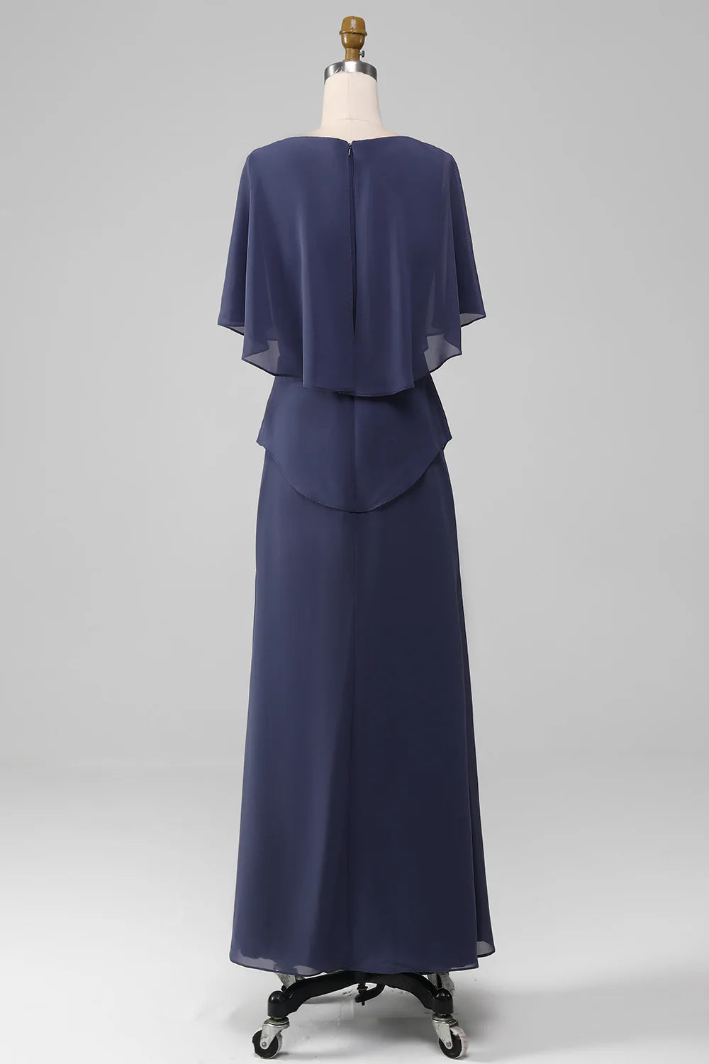 Woman in stormy blue sheath tea-length chiffon dress, side view.