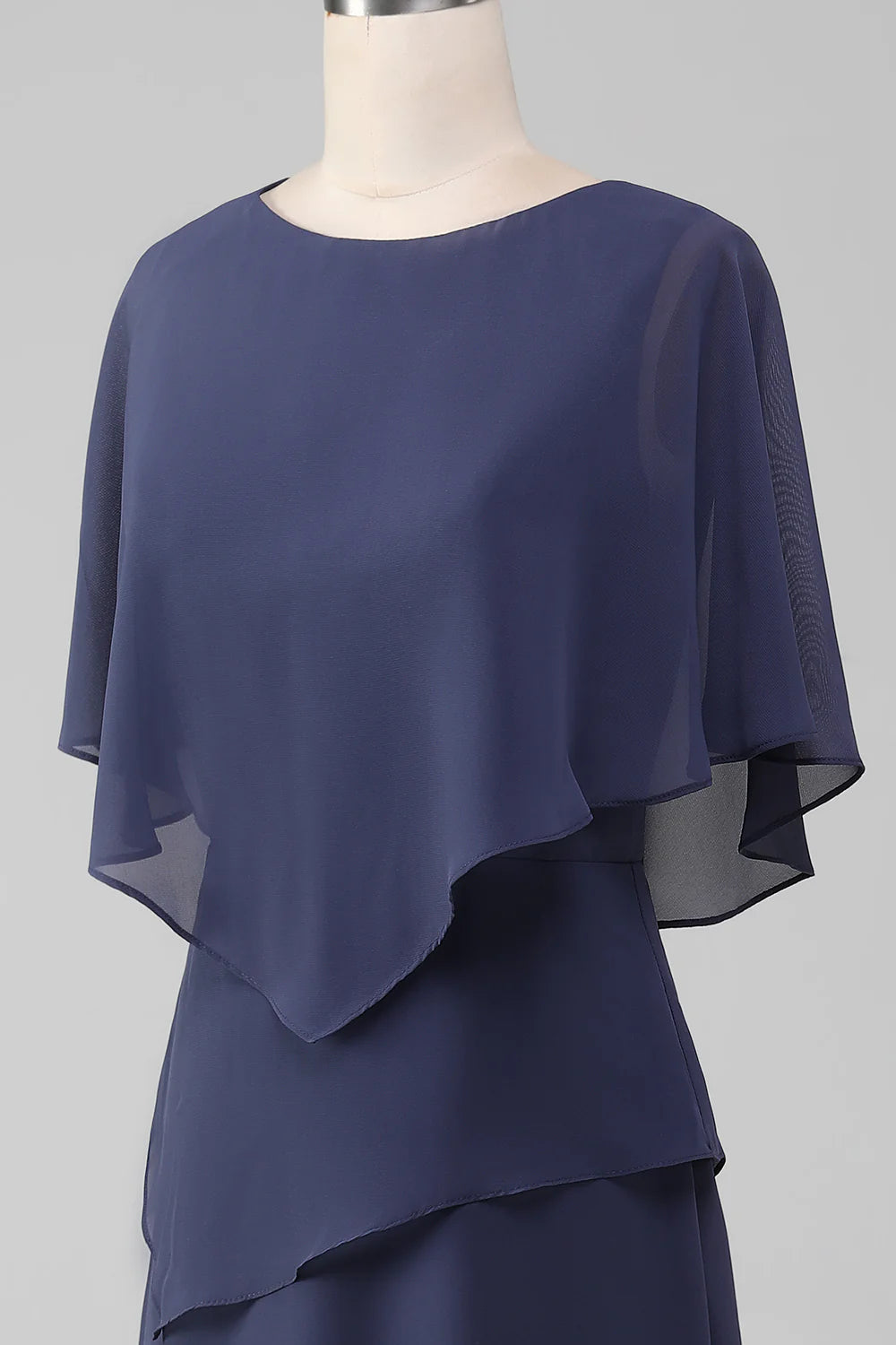 Woman in stormy blue sheath tea-length chiffon dress, showing movement.