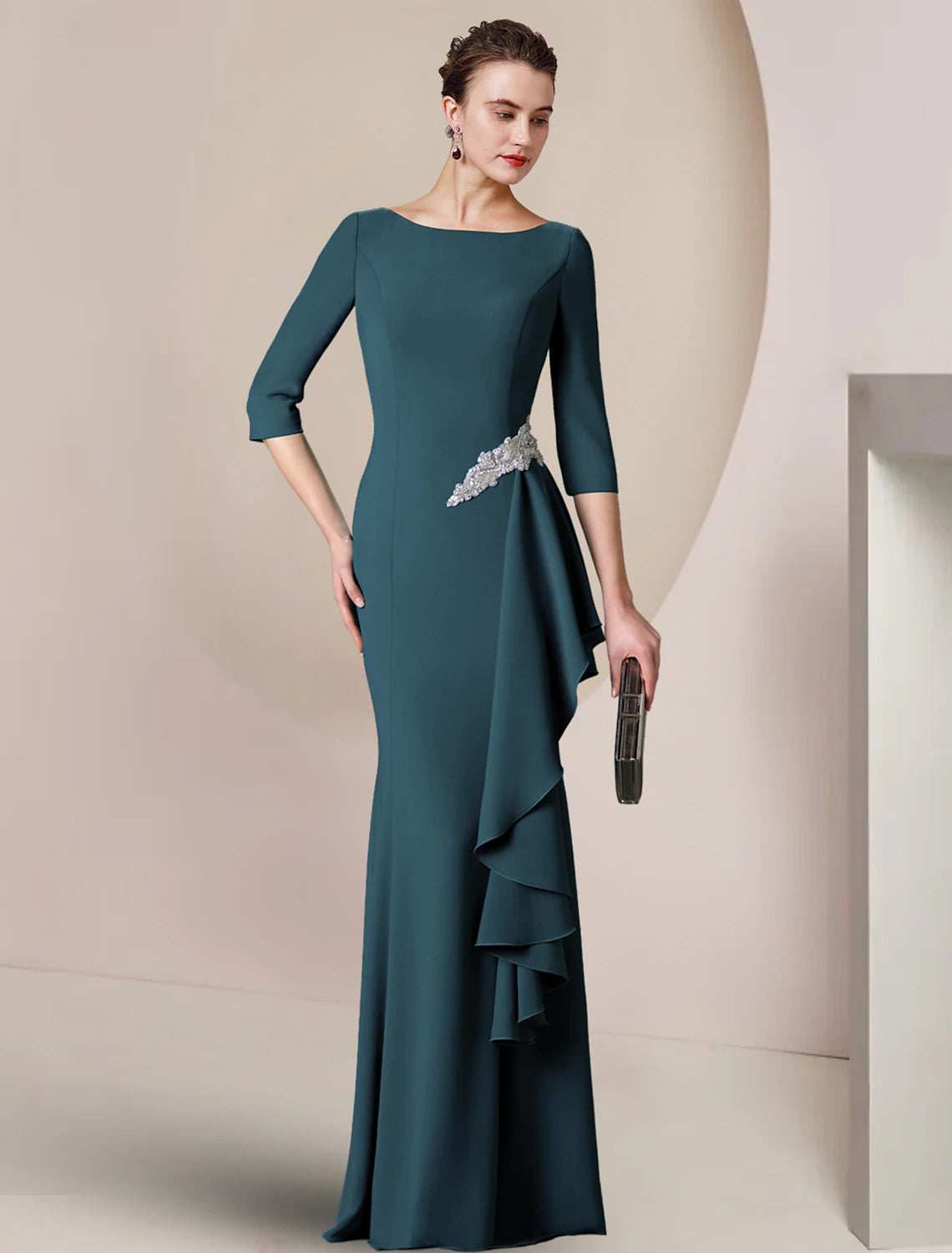Elegant woman wearing a floor-length sheath Mother of the Bride dress with a scoop neck and 3/4 sleeves.