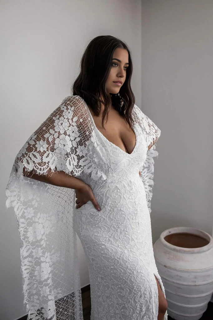 Front view of a bride in a romantic lace wedding gown with a scoop neckline.