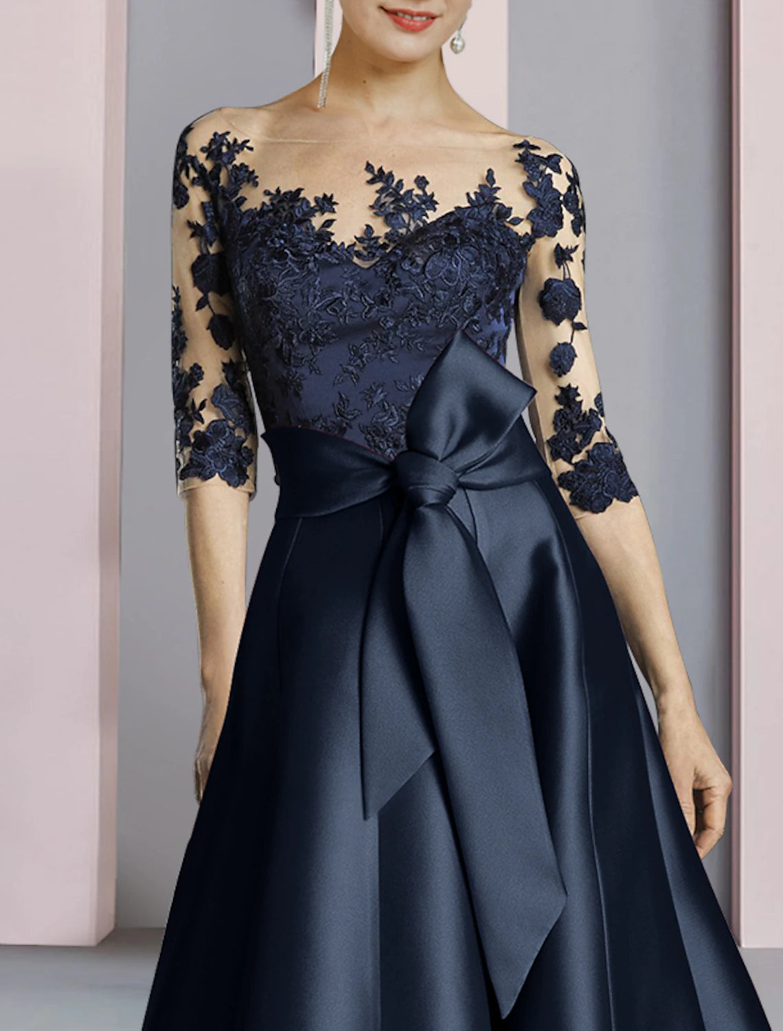 Back view of the ankle-length satin lace dress with pleats.