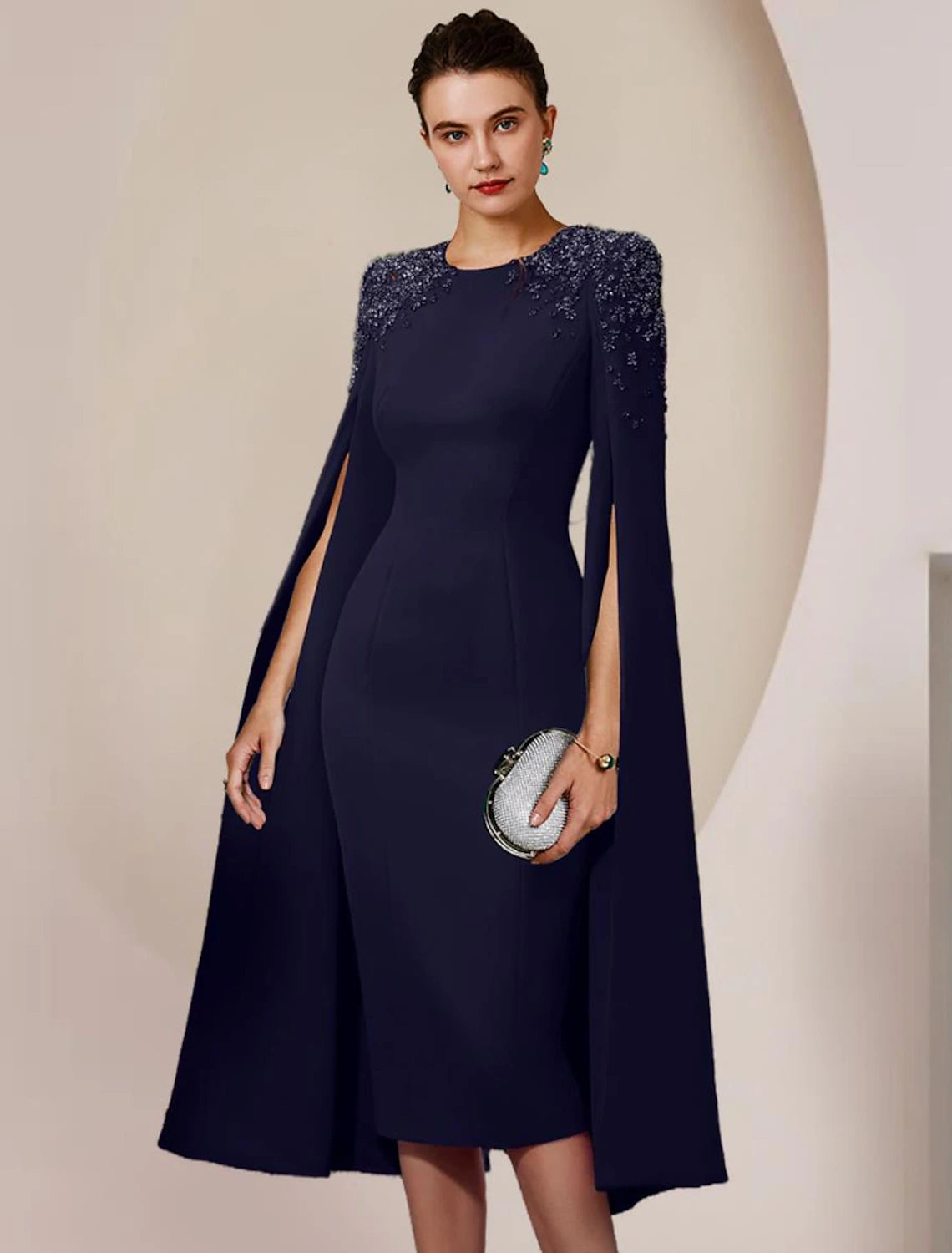 Woman wearing an elegant long-sleeve, knee-length sheath dress with beading.