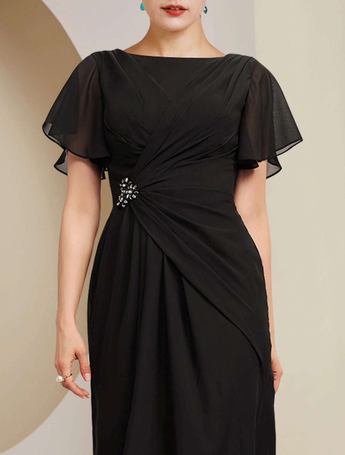 Side view of the ankle-length chiffon dress, showing side-draped detail and crystal brooch.