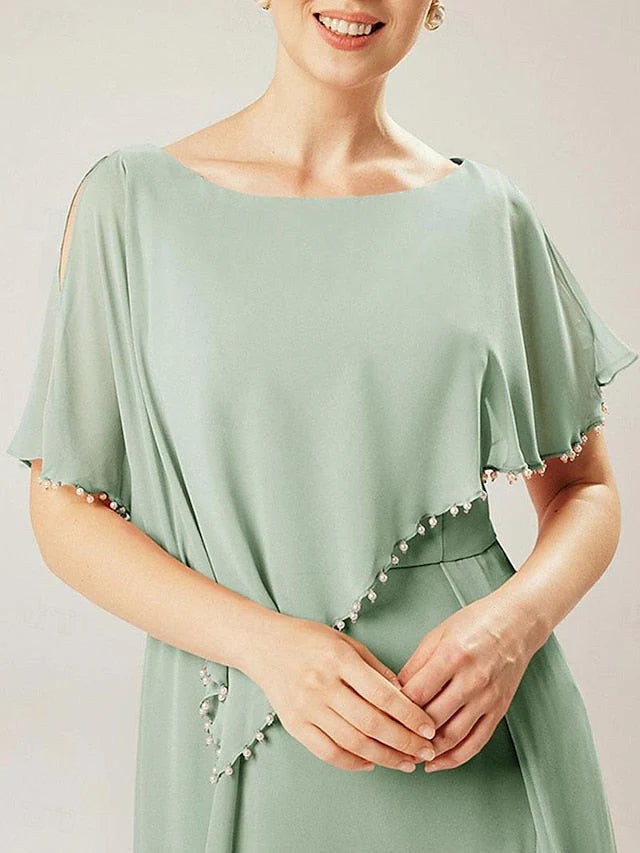 Woman wearing a green sheath mother of the bride dress with short sleeves.