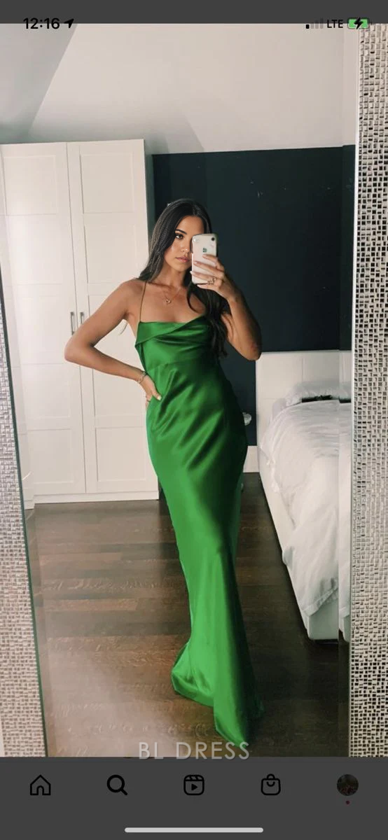 Woman wearing an elegant green sheath gown with spaghetti straps.