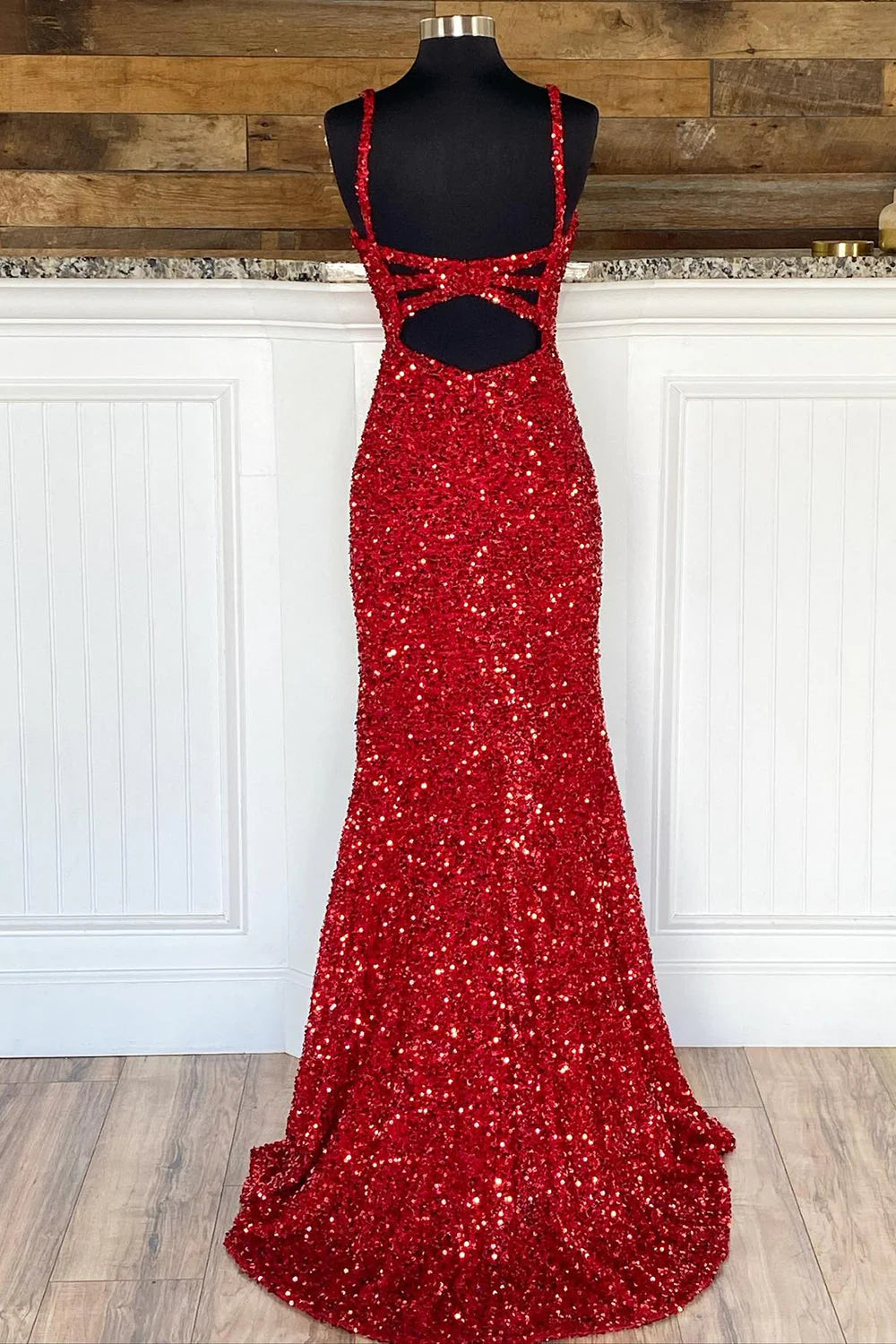 Side view of a woman wearing the red sequin sheath prom dress, highlighting the split front.