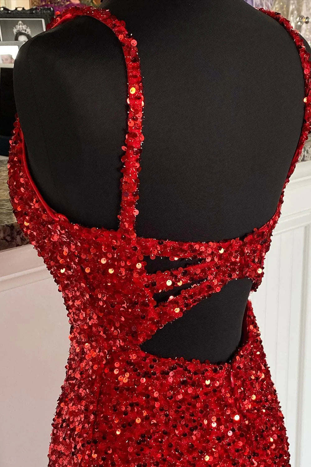 Close-up of the shimmering sequin fabric on the red sheath prom dress.