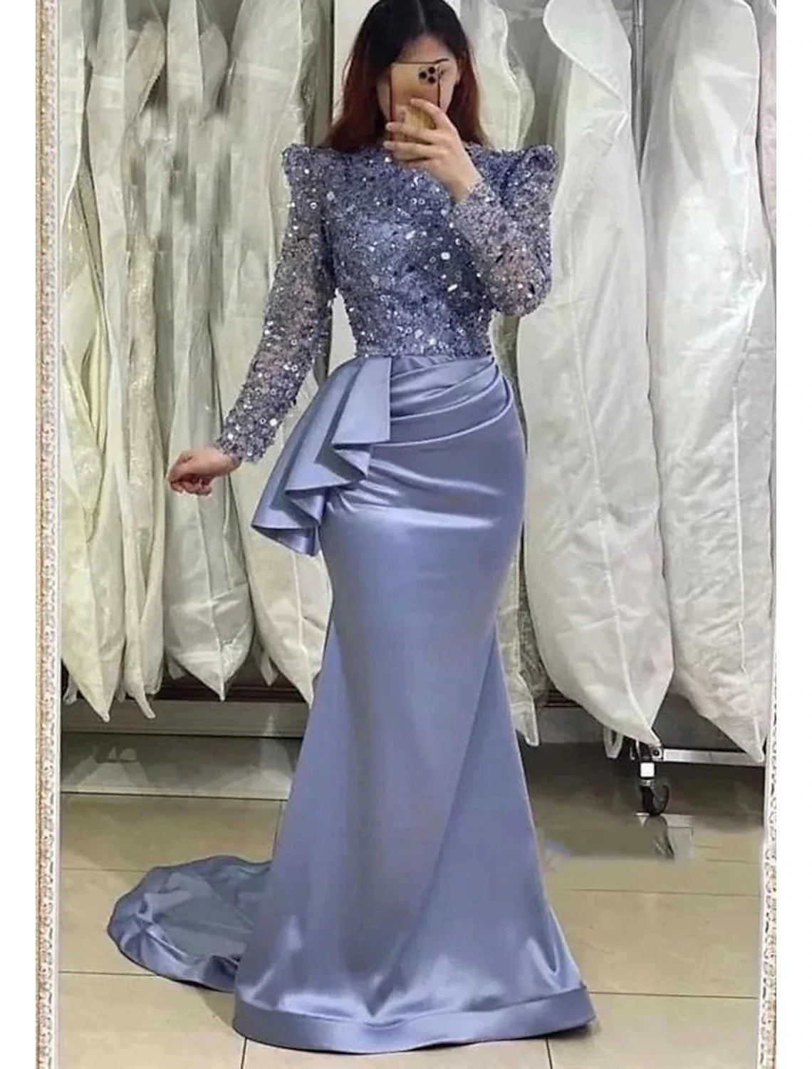Back view of a black tea length formal dress with feather detail.