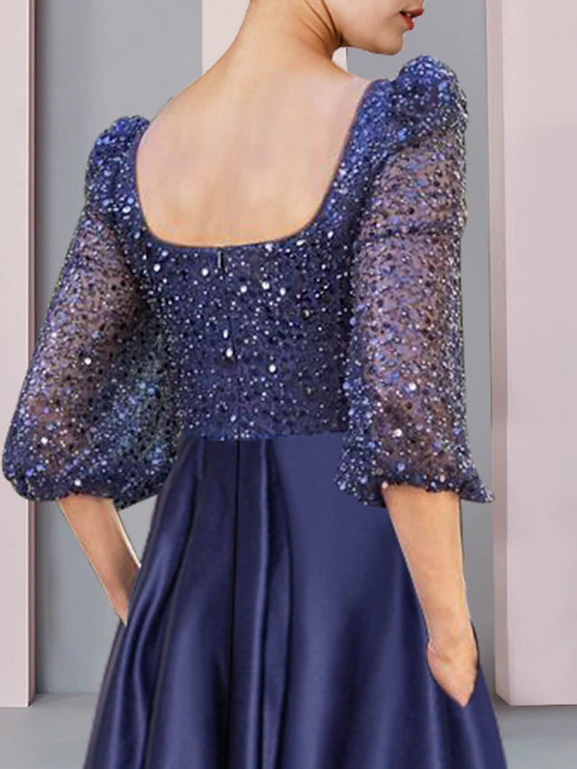 Side profile of a satin and lace sheath dress featuring pleats and beading.