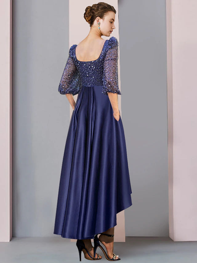 Close-up of the sparkling details and asymmetrical hem on a formal wedding guest dress.