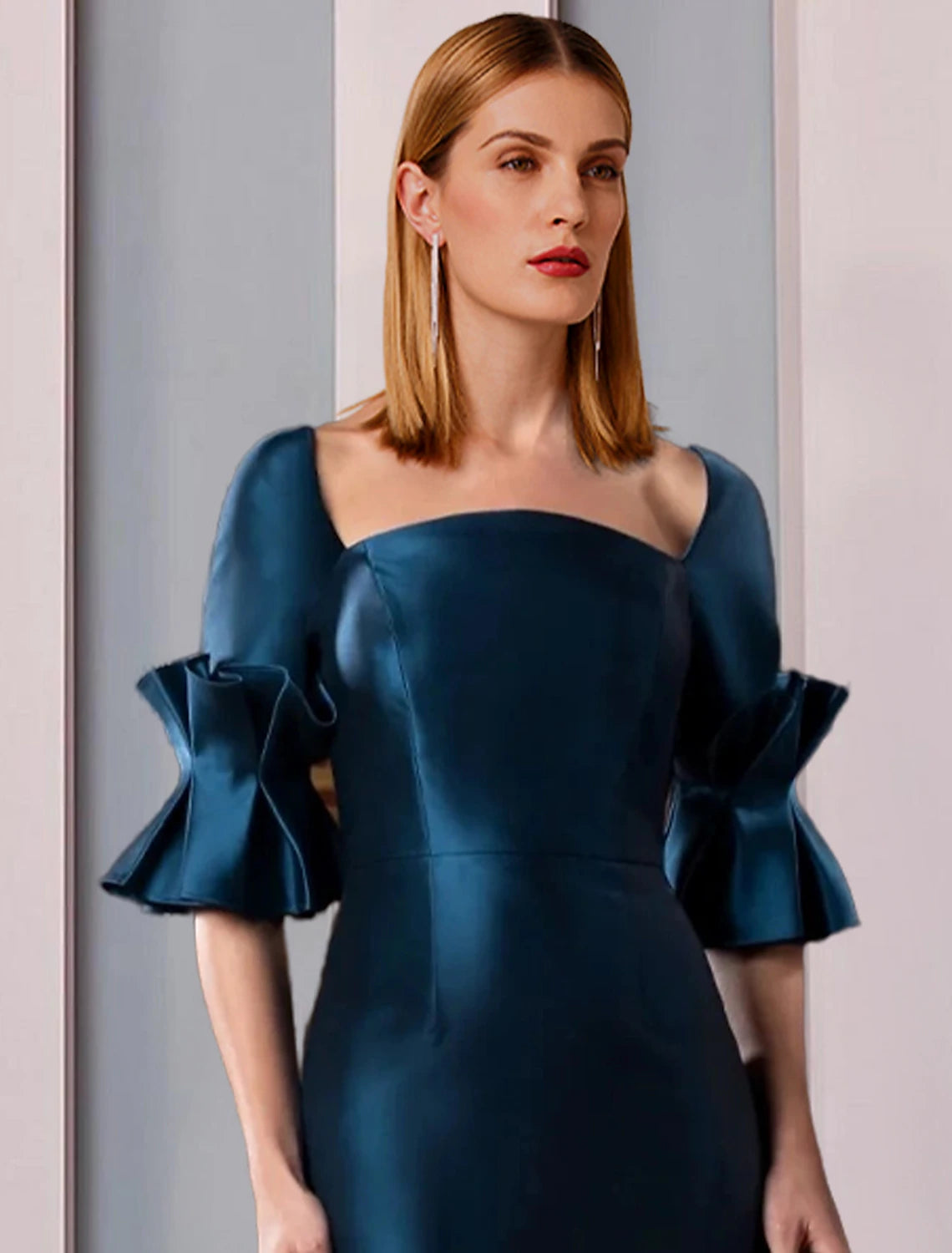 Close-up of the ruched half sleeve and square neckline on a satin dress.