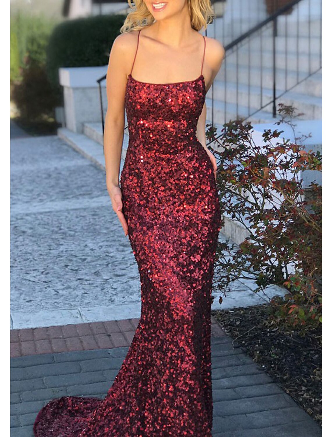 Side view of the sparkling sequined sheath dress, showcasing its sleek silhouette and sweep train.