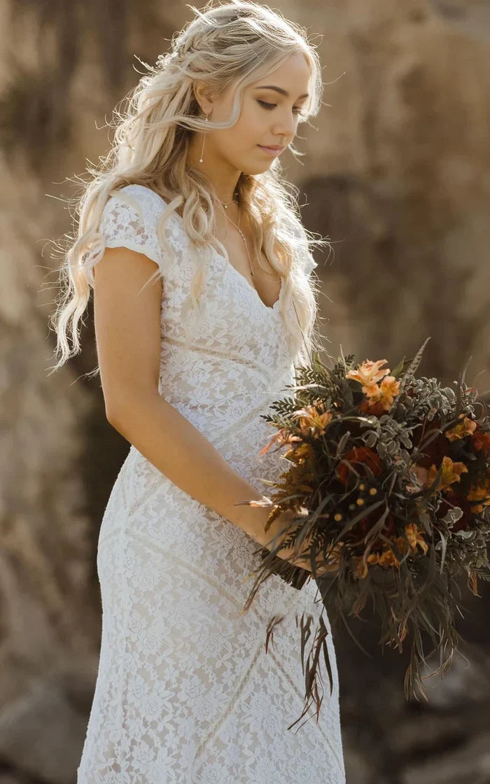 Close-up of the lace detail and square V-neckline on the short sleeve wedding dress.