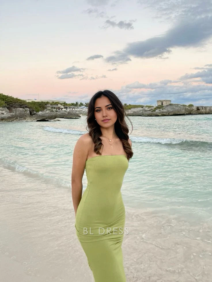 Woman wearing an elegant green strapless sheath formal dress.
