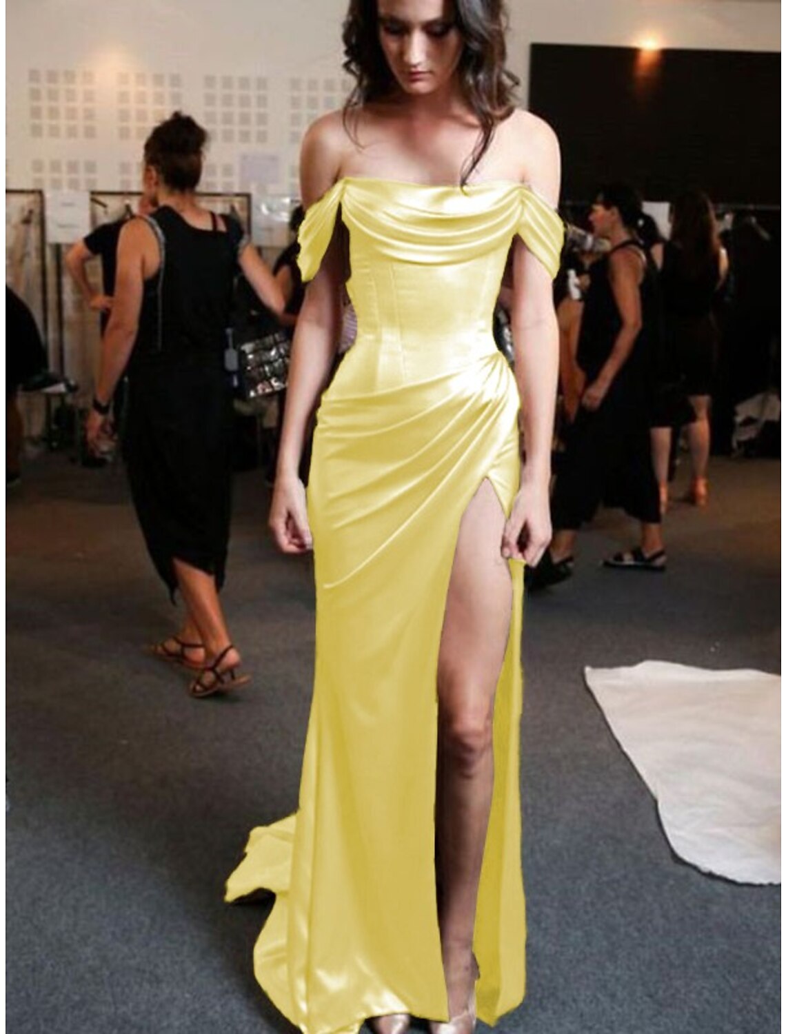 Woman posing in a strapless sheath prom dress, showcasing the full length and train.
