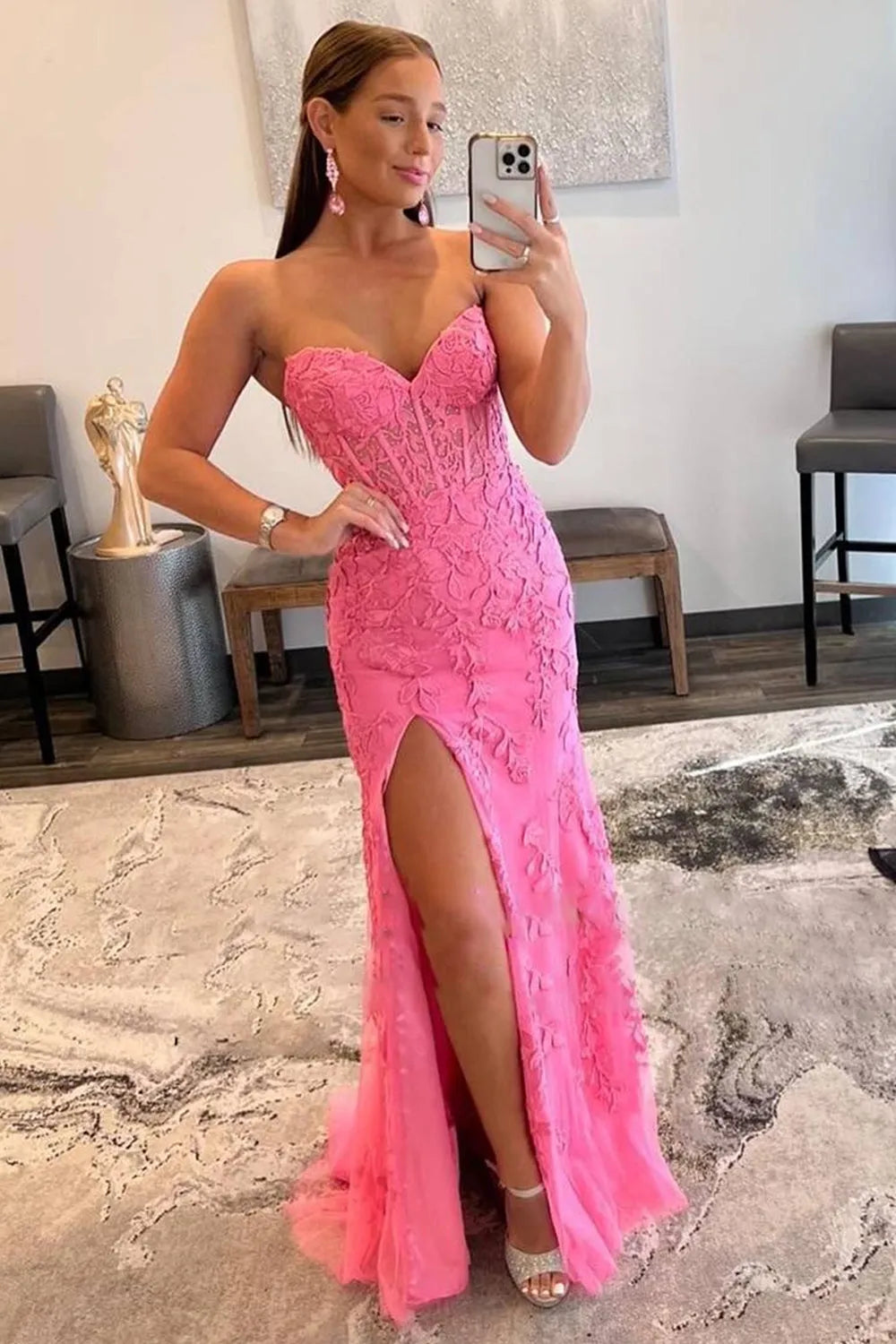 Model wearing a dark blue sheath prom dress with a sweetheart corset and high slit.