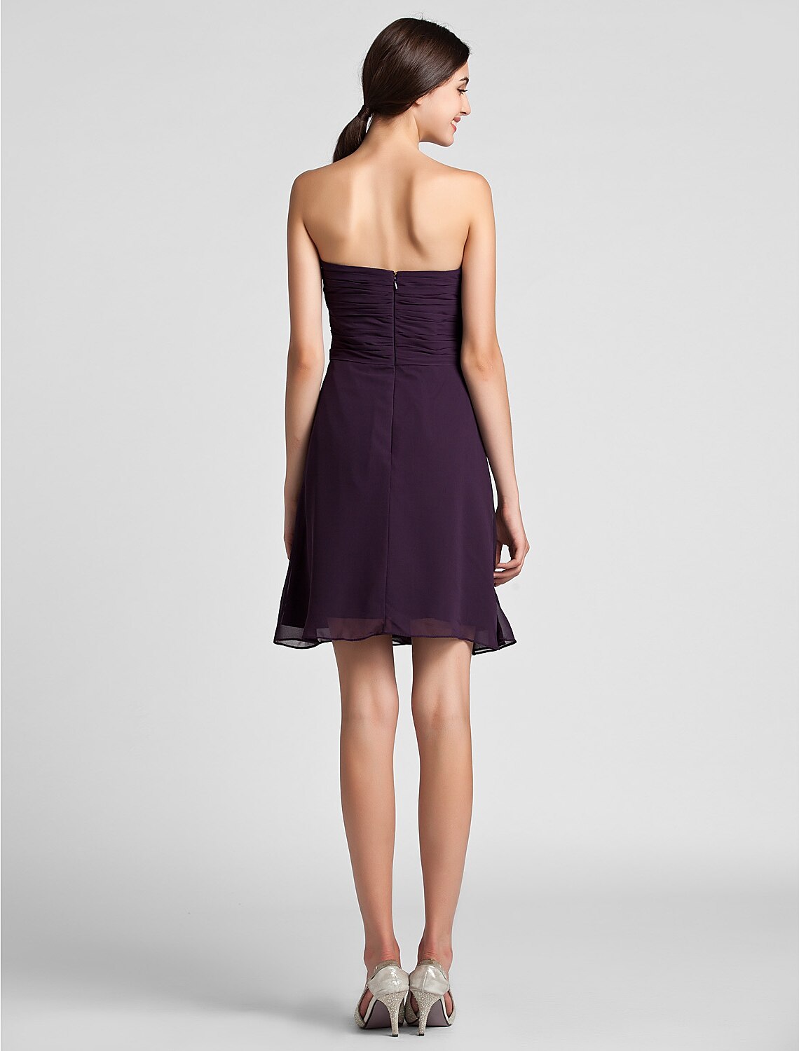 Side view of a woman in a sheath chiffon bridesmaid dress.