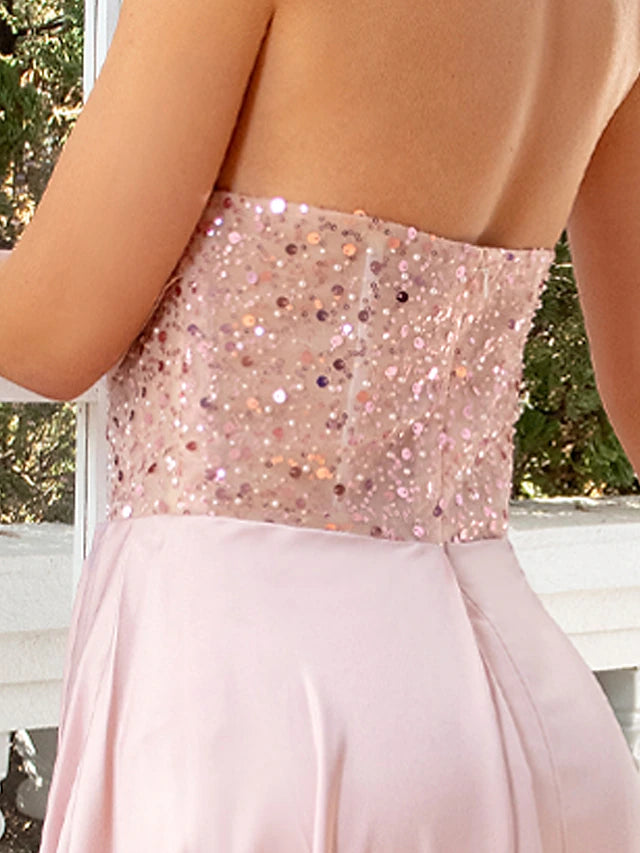 Detailed view of ruched satin fabric with pearl and sequin accents.