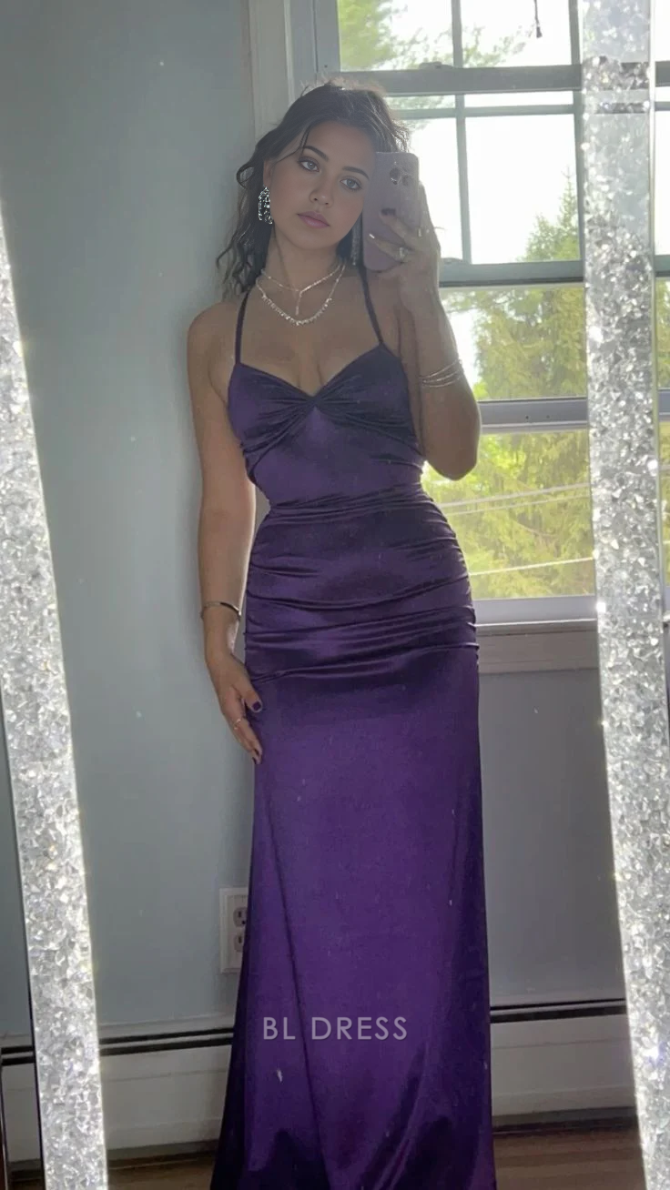 Woman wearing an elegant purple satin strapless sheath dress with a sweetheart neckline.