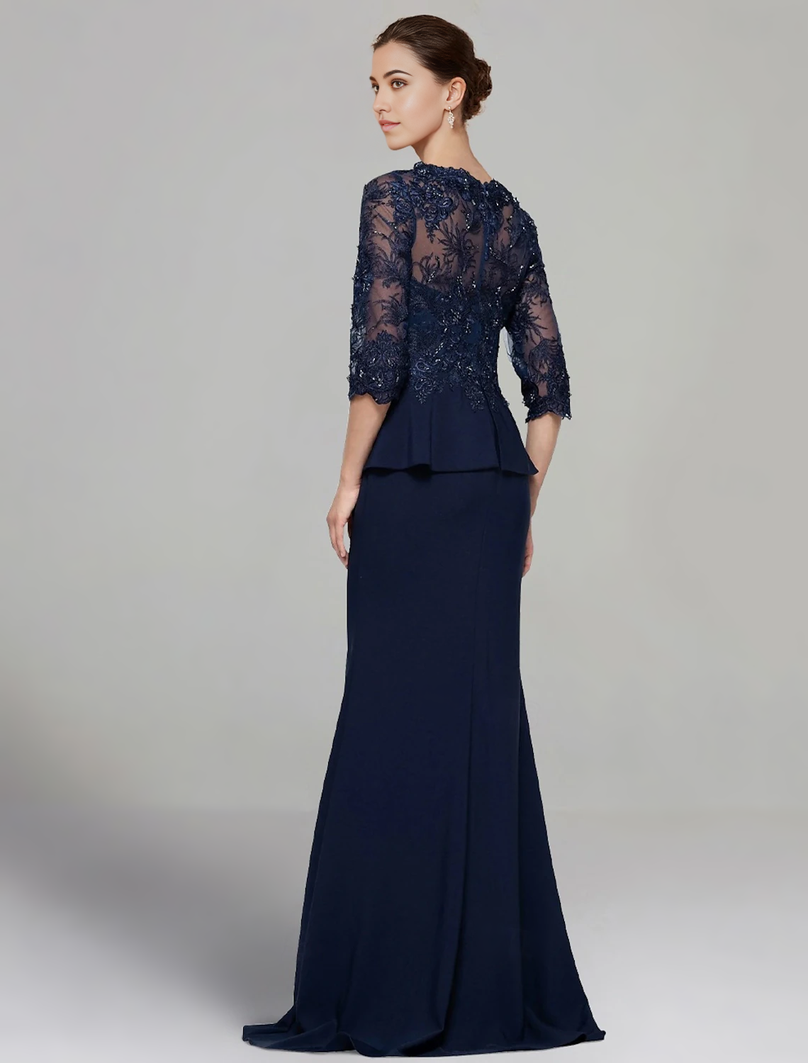 Back view of a floor-length sheath dress with delicate lace pleats.