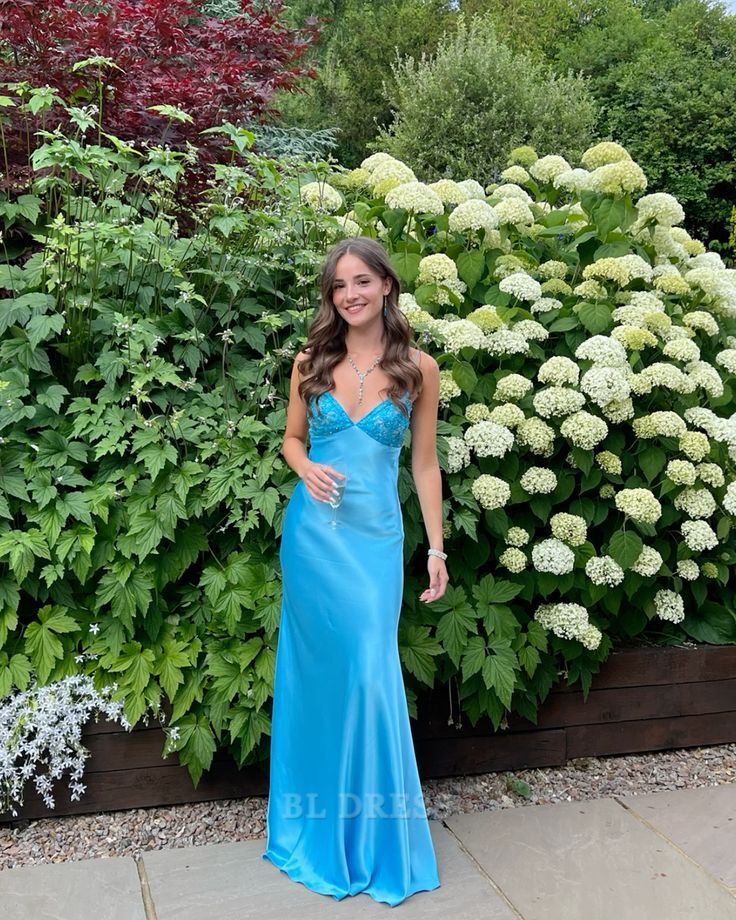 Model wearing a long blue V-neck sheath formal dress.